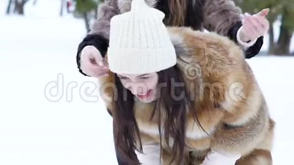 年轻无忧无虑的女孩在冬季公园玩耍慢慢地视频的预览图