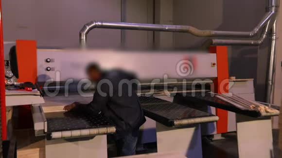 一个男人在一家家具厂工业内部为机器工作视频的预览图