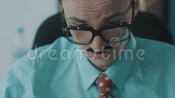 年轻的男办公室职员戴着巨大的眼镜还有滑稽的打哈欠视频的预览图