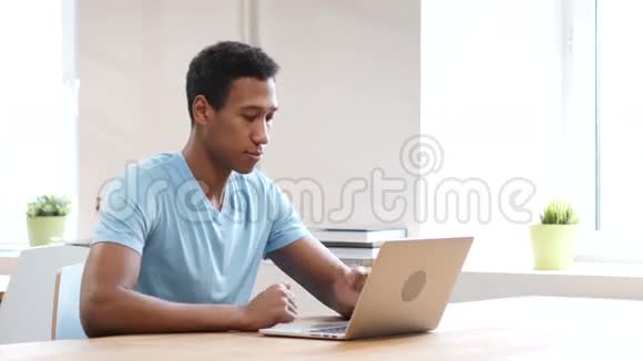 悲伤的黑人因失去而心烦意乱在笔记本电脑上工作视频的预览图