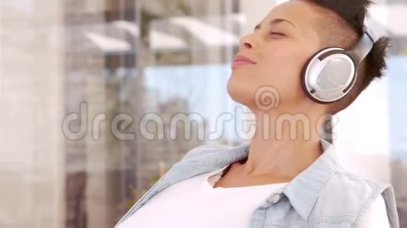 快乐的孕妇听音乐把耳机放在肚子上视频的预览图