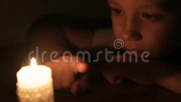 那男孩触摸燃烧的蜡烛的蜡视频的预览图