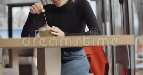 年轻的金发女孩在餐馆里喝茶视频的预览图