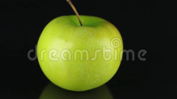 在黑色背景上旋转绿色苹果水果视频的预览图