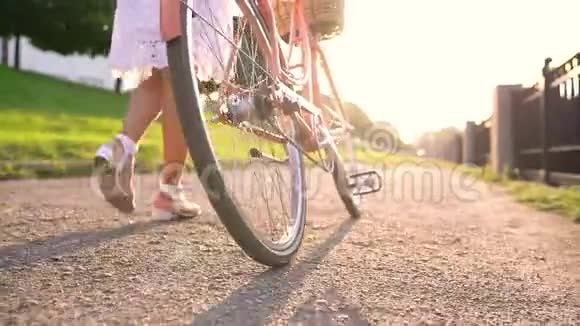日落时分年轻的美女骑着自行车散步视频的预览图