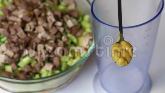 带有蔬菜和蛋黄酱的俄罗斯肉沙拉蛋黄酱的芥末勺子和沙拉的配料容器视频的预览图