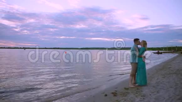 湖岸上一对相爱的情侣拥抱亲吻那人拿起脚后跟转动着视频的预览图