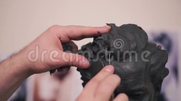 一位雕塑家在他的作坊里创作他的泥塑作品剪辑一个人切割一个粘土模子视频的预览图