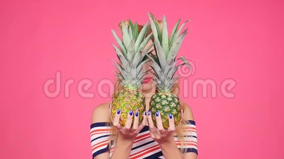 时尚夏季肖像年轻漂亮的女人拿着两个大甜菠萝视频的预览图