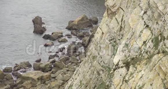 水冲击岩石时悬崖底部的近景视频的预览图