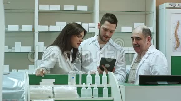 微笑的药剂师团队两男一女并排站在药房核对信息上视频的预览图