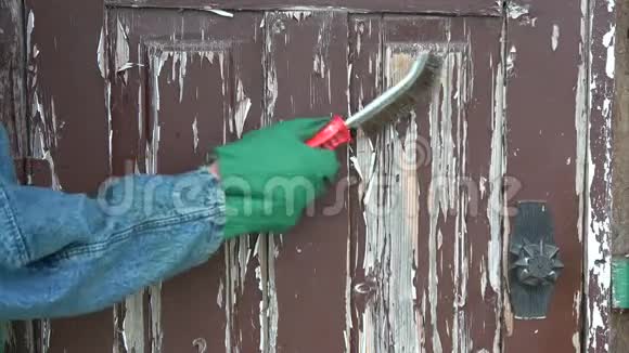 用金属刷刮去木门上的旧油漆视频的预览图
