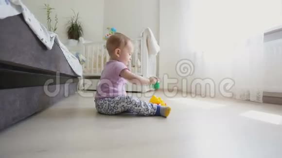 在客厅地板上玩耍的可爱的蹒跚学步的孩子的多莉照片视频的预览图