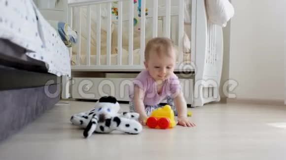 多莉拍了一张可爱的蹒跚学步的男孩躺在地板上玩玩具车视频的预览图