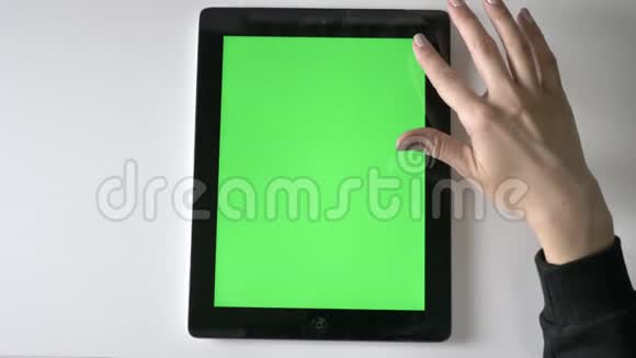 女性手在平板电脑上滚动绿色屏幕色度概念顶拍60fps视频的预览图