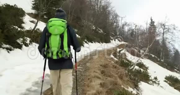 徒步旅行者背着背包走在雪地小径上后面跟着真正的背包客成人徒步旅行或徒步旅行视频的预览图