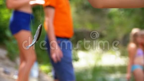 抓住了悬挂在钓鱼线上的钩子上的鱼钩捕鱼慢动作视频的预览图