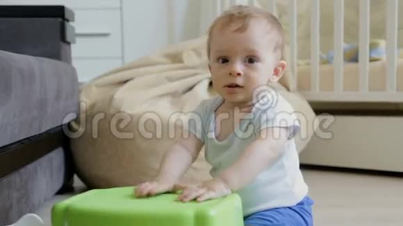 可爱的幼儿男孩坐在客厅的地板上打鼓视频的预览图