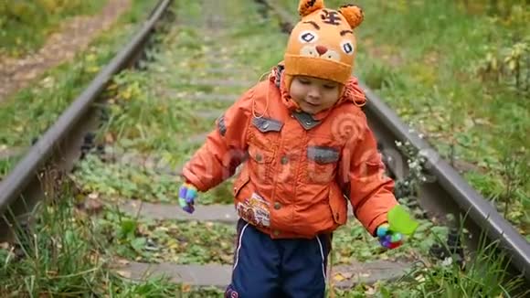 一个孤独的男孩走在铁轨上危险的游戏和娱乐活动秋日视频的预览图