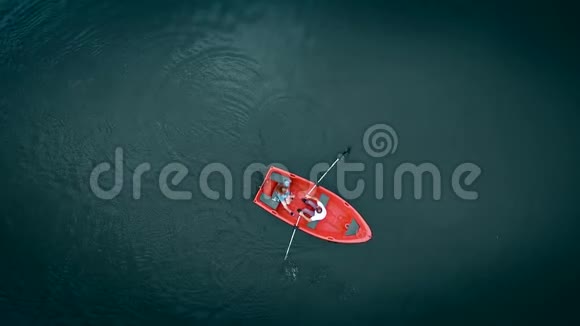 高空俯视图湖上红船顶景两个年轻人在船上航行视频的预览图