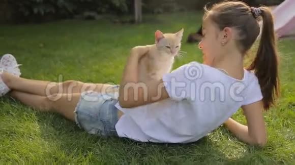 美丽的少女躺在草地上肚子上放着红猫视频的预览图