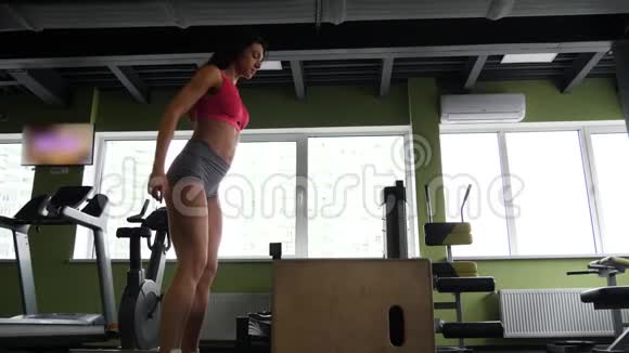 西班牙女人在一个交叉健身的健身房里跳上木箱视频的预览图