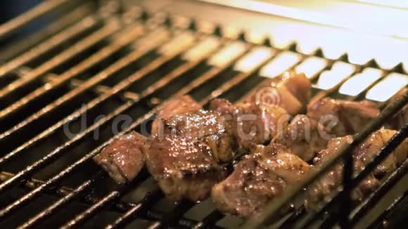 亚洲夜市一个小贩在烤架上烹制牛肉肉的慢动作视频的预览图