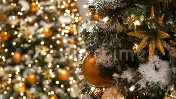 装饰精美的圣诞树上矗立着巨大的金银球星星花环和人造雪视频的预览图