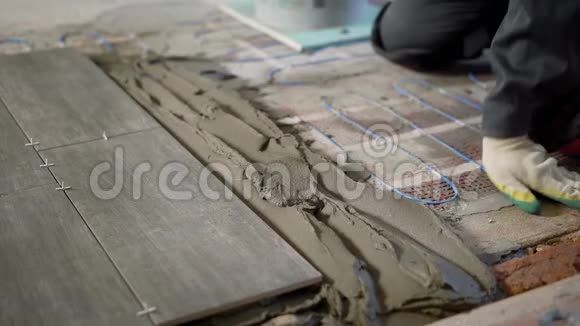 专业施工员在地板上涂水泥铺瓷砖视频的预览图