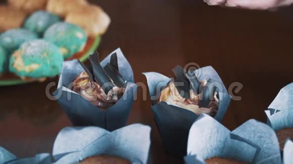 女人的糕点厨师手在桌子上装饰松饼和巧克力片视频的预览图