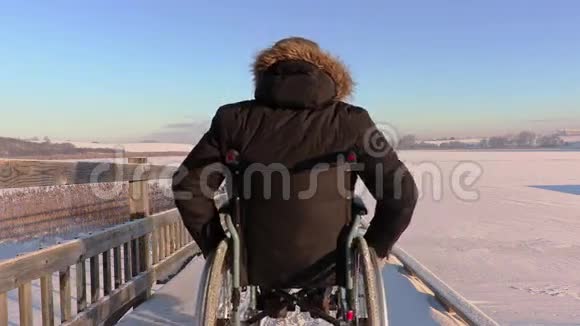 冬天在湖边坐轮椅的快乐残疾人视频的预览图