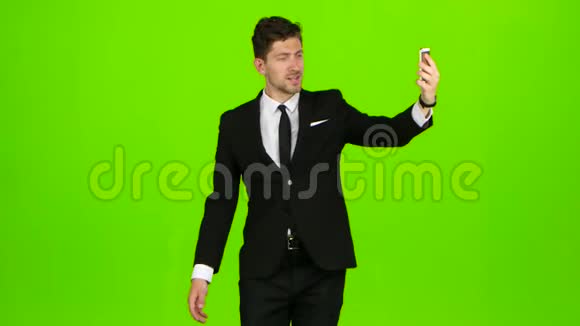 商人走路竖起大拇指笔记本自拍绿色屏幕侧视图视频的预览图