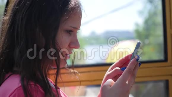 漂亮的女孩坐着手机视频的预览图