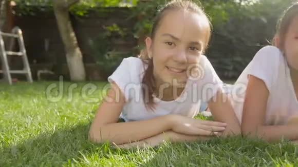 在公园草地上躺着两个微笑的女孩视频的预览图