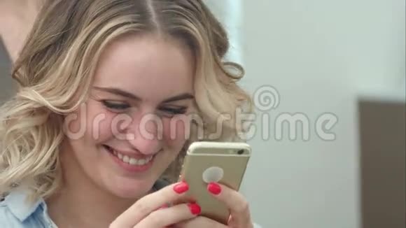 一位在沙龙做发型的女士一边用手机上网一边微笑视频的预览图