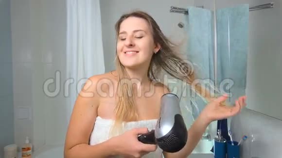 美丽的微笑女人淋浴后吹干头发的慢镜头视频的预览图