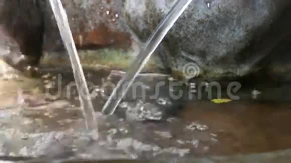 关闭花园喷泉处的水滴水滴溅在水面上视频的预览图
