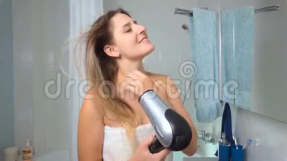 美丽的年轻女子洗澡后吹干头发的慢镜头视频的预览图