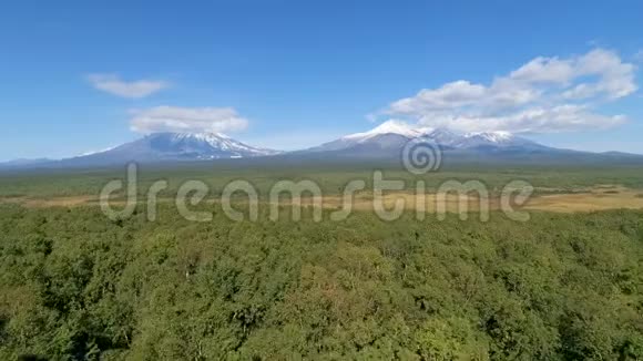 云层后面的火山和森林空中射击视频的预览图