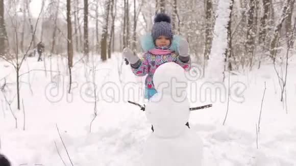 小朋友在冬季公园堆雪人视频的预览图
