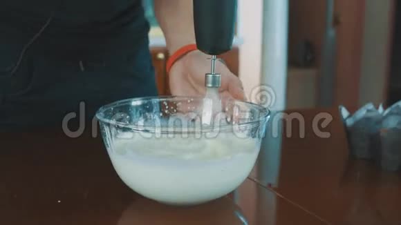 肌肉男用搅拌器将牛奶倒入玻璃碗中视频的预览图