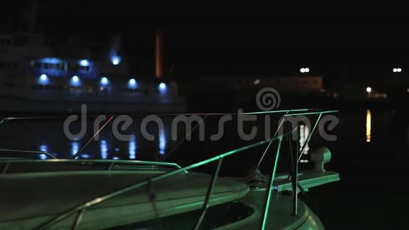船舶游艇在海港的波浪上在夜晚的色彩面前照明视频的预览图