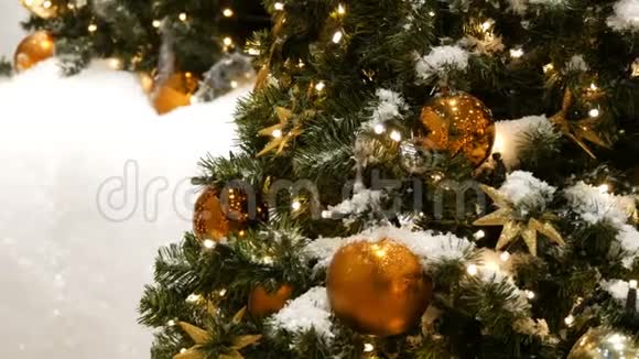 装饰精美的圣诞树上矗立着巨大的金银球星星花环和人造雪视频的预览图