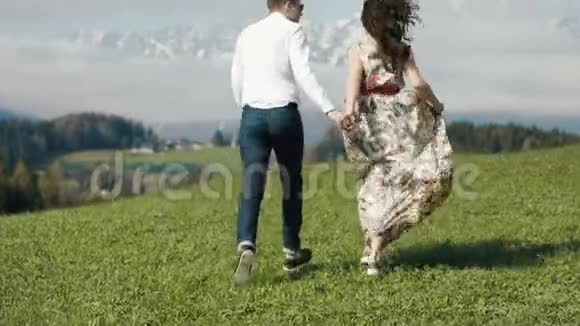 山野草甸欢乐奔跑夫妇的后景视频的预览图