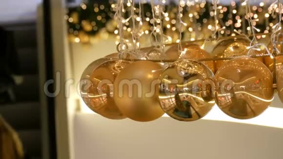 圣诞花环的灯光和金色的球背景模糊新年和圣诞装饰视频的预览图