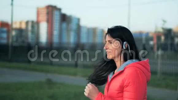 穿运动服装的漂亮女孩在城市公园慢跑视频的预览图