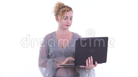 快乐的金发美女一边说一边用笔记本电脑视频的预览图