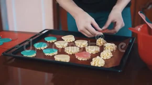 奶油蛋糕女性在托盘上的奶油堆上放红色面团圈视频的预览图