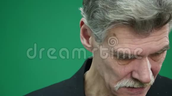 悲伤的老人被隔离在绿色的背景上哭特写摄影棚的肖像视频的预览图