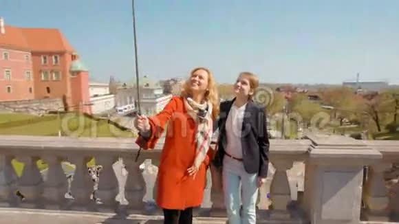 两个年轻的女朋友在城市的背景下和莫诺波德做自拍视频的预览图